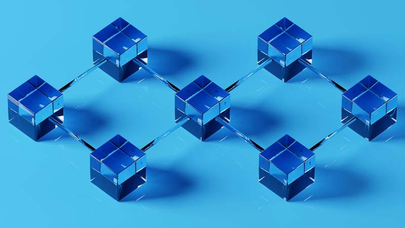 Diverse group of developers collaborating around a monitor showing blockchain architecture diagram and terminal output